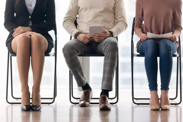 Applicants waiting for job interview, sitting on chairs and prep