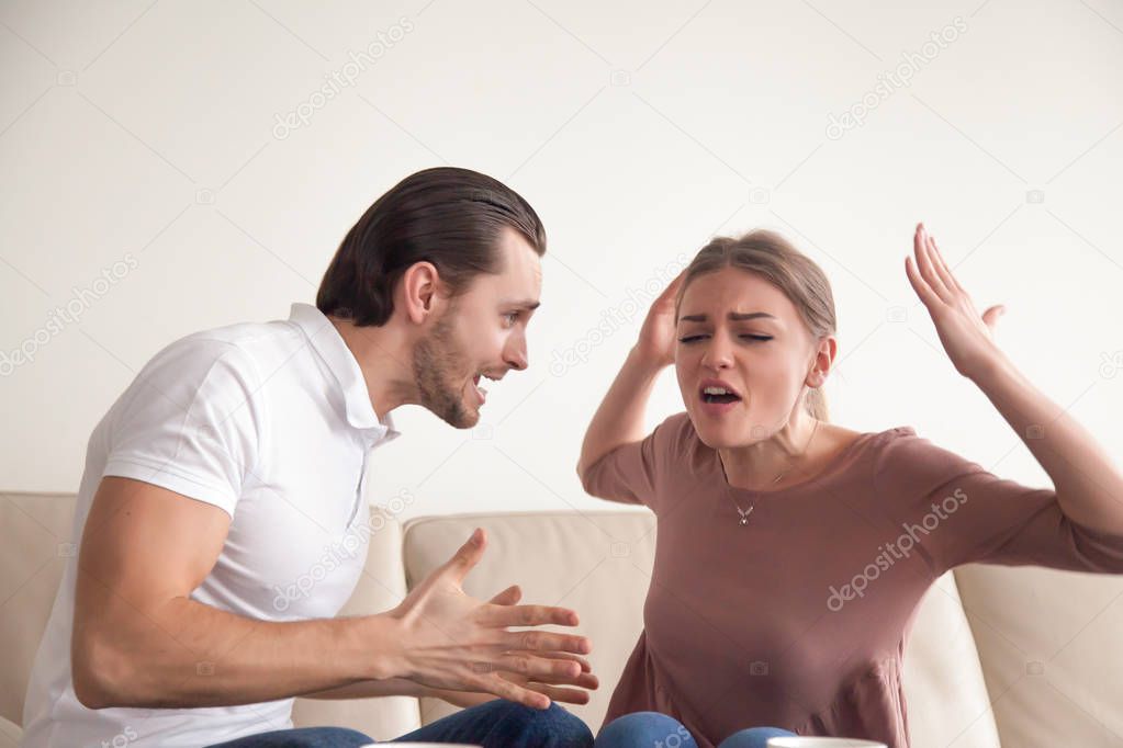 Young couple quarrelling, shouting and blaming each other for pr