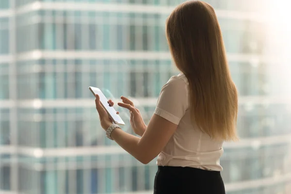 Mujer vista trasera deslizar con el dedo en la pantalla de la tableta —  Fotos de Stock