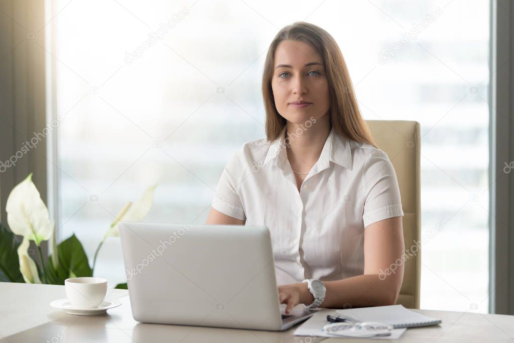 Female office worker doing daily work on laptop