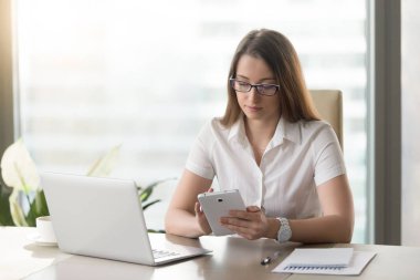 Genç iş kadını masada bilgisayar tablet kullanma