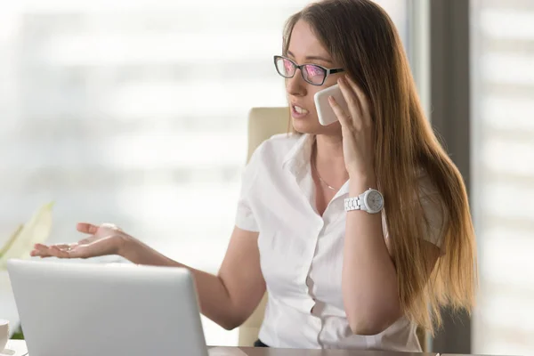 Busy female entrepreneur arguing by phone — Stock Photo, Image