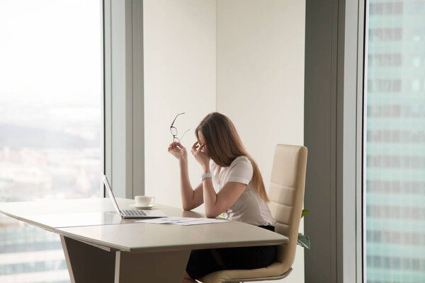 Exhausted businesswoman sitting at office