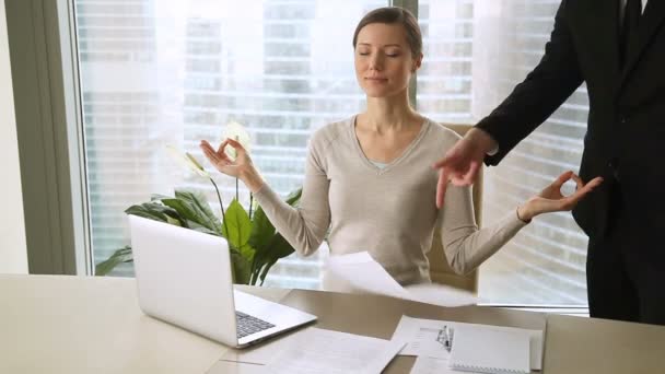 Молода спокійна бізнес-леді, що медитує на робочому місці, сердитий бос розібрався зі співробітником — стокове відео