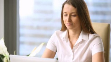 Ofiste çalışan, kameraya bakıyor ve gülümseyen kadın Yöneticisi