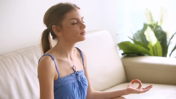 Mooie jonge vrouw thuis te mediteren, ademen lucht, het beoefenen van yoga — Stockvideo