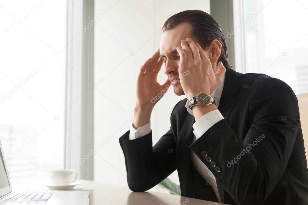Businessman suffering from migraine or headache
