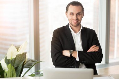 Kendine güvenen işadamı işyerinde poz