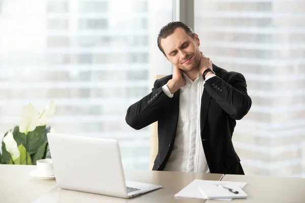 Empresario masajeando sus tensos músculos del cuello —  Fotos de Stock