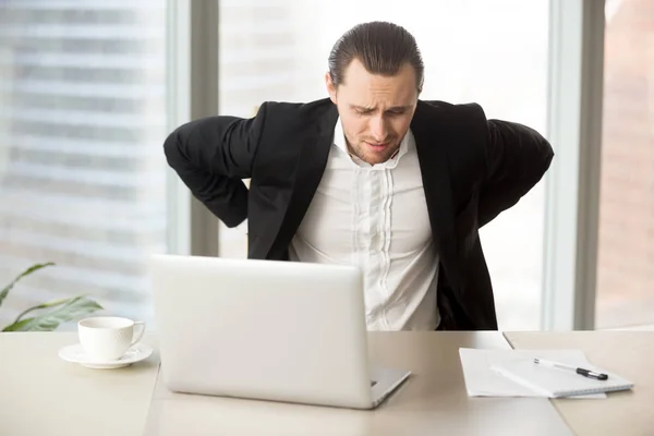 Biznesmen, cierpiących na bóle pleców w miejscu pracy — Zdjęcie stockowe