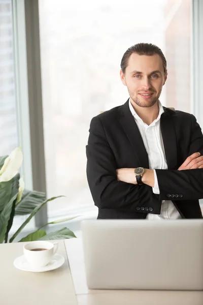 Portrait of CEO sitting at desk with arms crossed — Stock Photo, Image