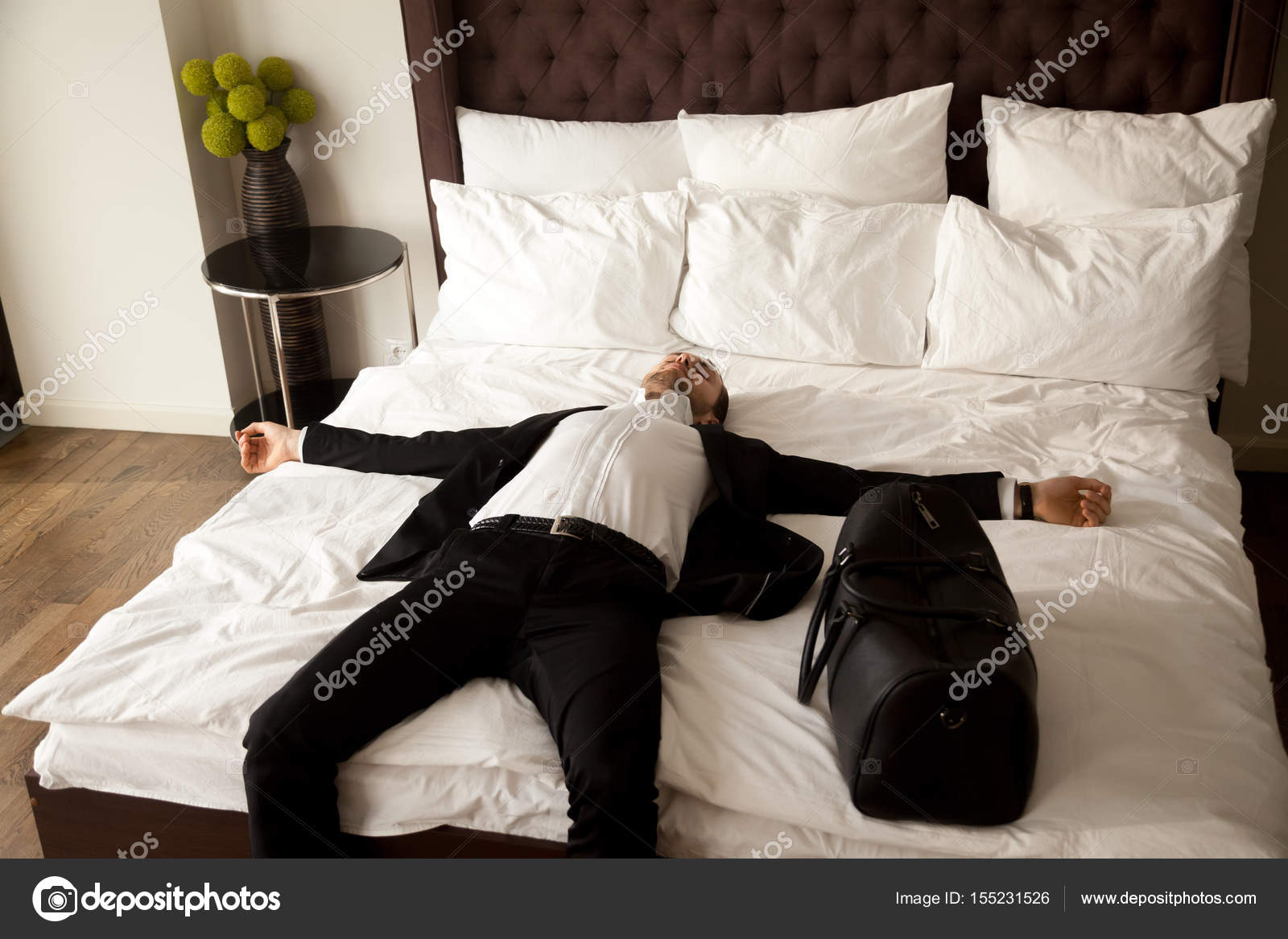 Мужчина в номере отеля. Парень в кровати. Парень в костюме на кровати. Мужчина в костюме лежит.