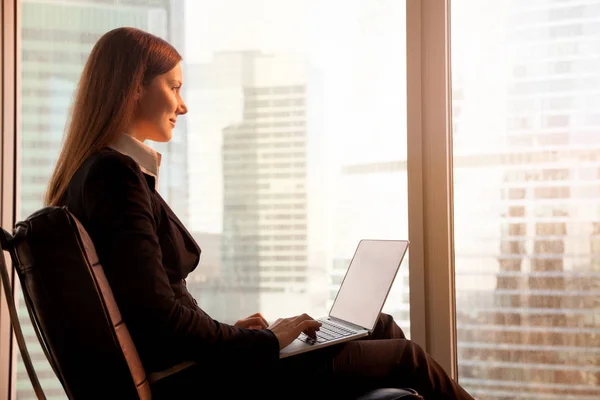 Atractiva empresaria disfrutando del atardecer, relajándose en la oficina cha — Foto de Stock