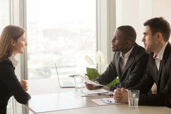 Female applicant and multiracial recruiters during job interview