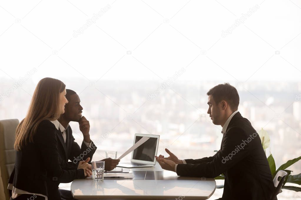 Male applicant and multi-ethnic recruiters during job interview,
