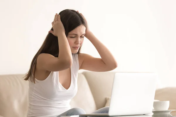 Жінка страждає від головного болю під час роботи на ноутбуці — стокове фото