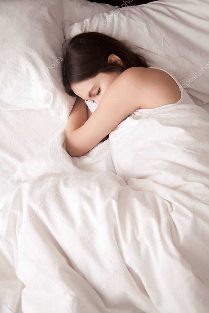 Female student lying in bed until late morning