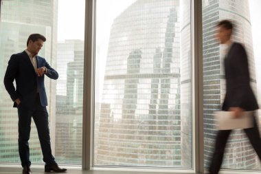 Toplantı için bekleyen işadamı kol saati içinde zamanında kontrol