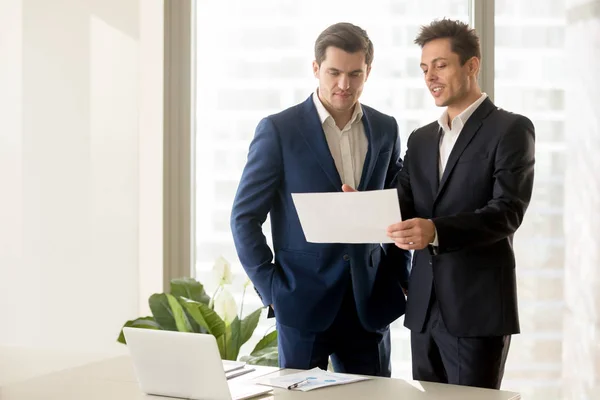 Dos hombres de negocios sonrientes hablando de la inversión elegible, discu — Foto de Stock