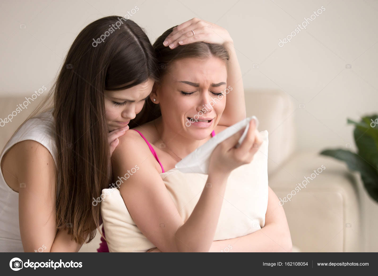 Young Woman Tries To Comfort Crying Female Friend Stock Photo