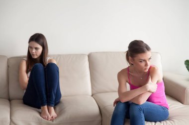 Ayrı koltukta oturan iki genç kızgın kadın