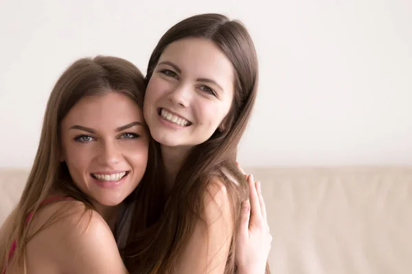Dos mujeres felices abrazándose y mirando en la cámara —  Fotos de Stock