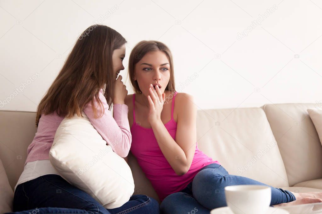 Two young women telling gossips and secrets