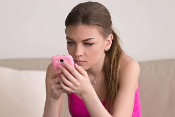 Grave giovane donna che utilizza il cellulare a casa — Foto Stock