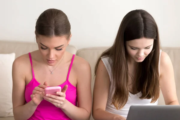 Två flickvänner med hjälp av mobiltelefon och bärbar dator — Stockfoto