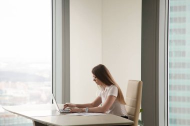 Ofis iç, copyspa içinde laptop üzerinde çalışan ciddi meşgul kadın