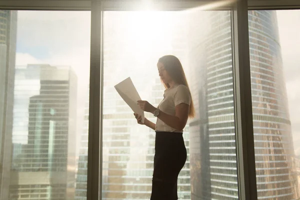 Busy serious businesswoman holding reading document, standing ne — Stock Photo, Image