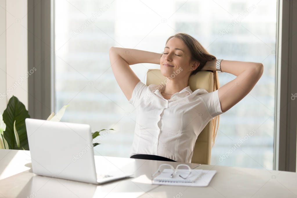 Calm smiling businesswoman relaxing at comfortable chair hands b