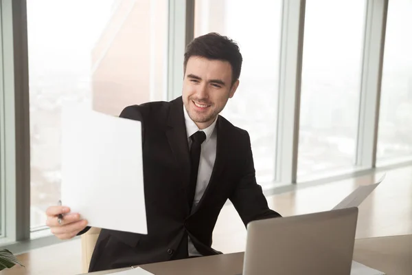 Happy businessman holding financial statistics report, satisfied — Stock Photo, Image