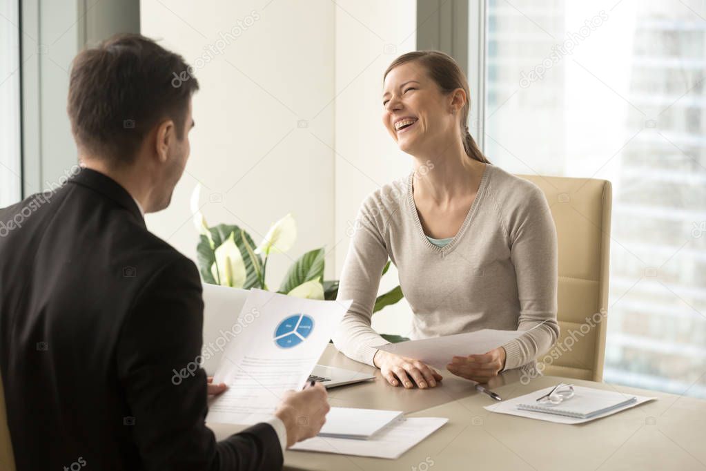 Happy positive colleagues laughing during meeting, having fun at
