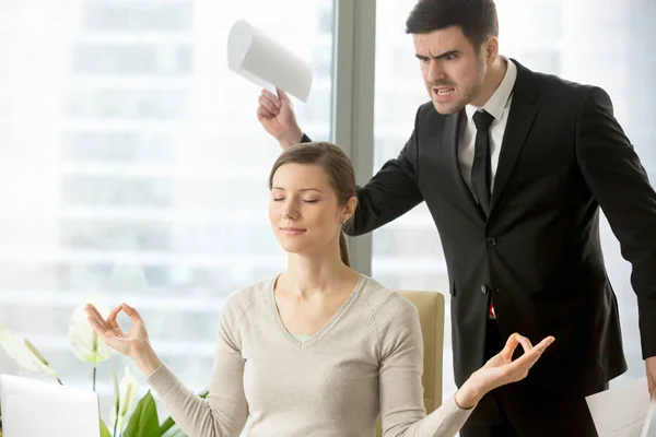 Спокійна приваблива бізнес-леді, що медитує в офісі, ігноруючи гнів — стокове фото