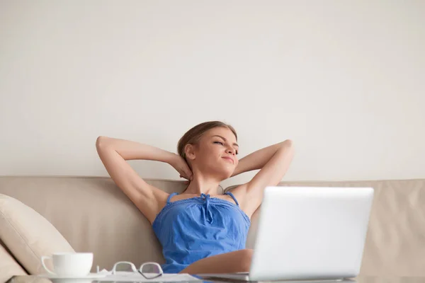 Vrouw rust op de sofa thuis na het werk — Stockfoto