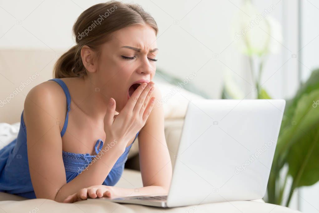Tired woman yawning after too long work on laptop