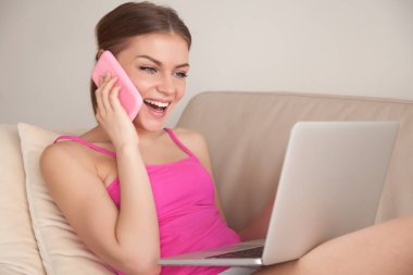 Mutlu kadın laptop kullanırken cep telefonunuzun konuşma