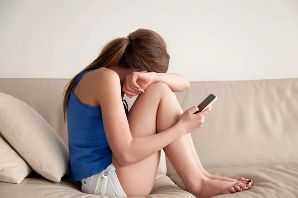 Ragazza adolescente che piange dopo aver letto il messaggio sul telefono — Foto Stock
