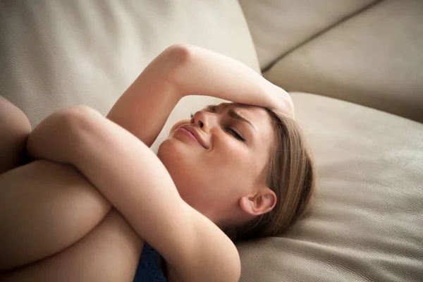 Stressad dam liggande på soffan hemma och gråter — Stockfoto