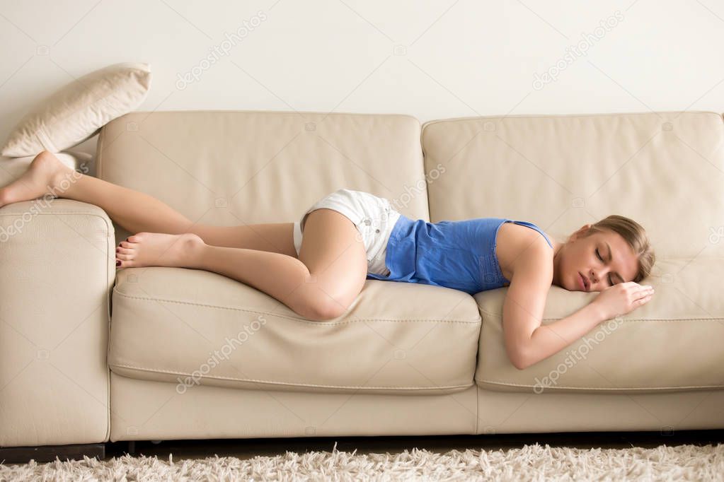 Tired woman stretches out and sleeps on sofa