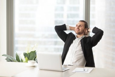 Mutlu gülümseyen iş adamı rahatlatıcı, modern ofis çalışma masası