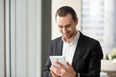 Gülümseyen mutlu yakışıklı işadamı elektronik tablet vasıl arıyorsunuz.