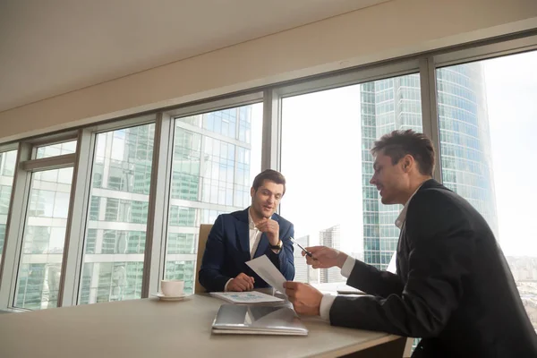 Dos hombres de negocios discutiendo tasas de crecimiento en reunión —  Fotos de Stock