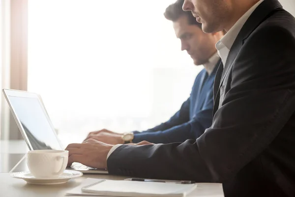 Funcionários da empresa trabalhando em laptops no escritório — Fotografia de Stock