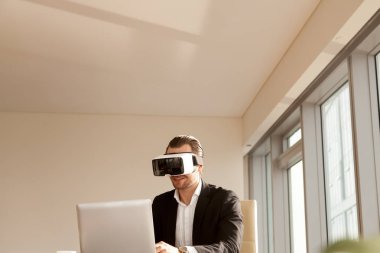 İşadamı vr kulaklık test uygulamasında laptop gülümseyen.