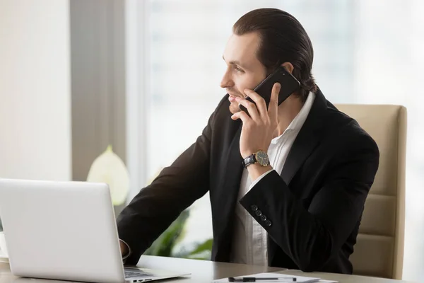 Sonriente hombre de negocios guapo en la oficina moderna hablando en cellpho — Foto de Stock