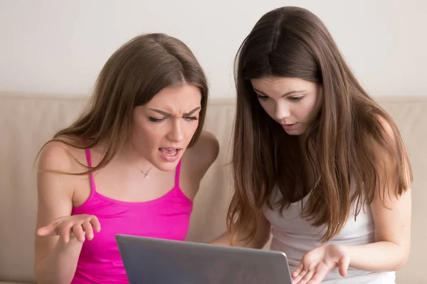 Twee jonge gefrustreerd meisjes kijken laptop computerscherm. — Stockfoto