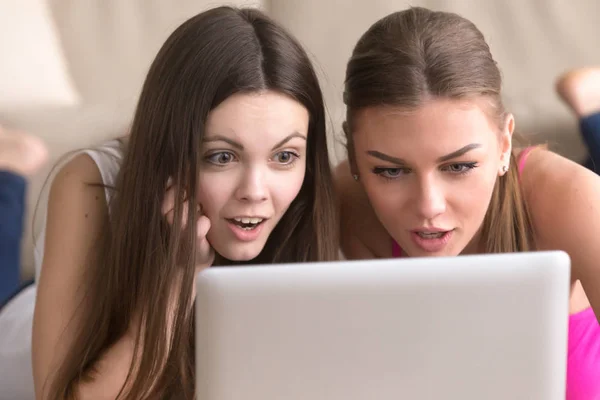 Twee vriendinnen op zoek naar laptop scherm met expressie van exci — Stockfoto