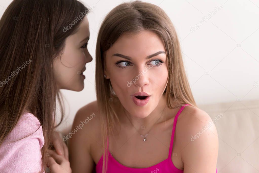 Young girl telling her best friend personal secret.
